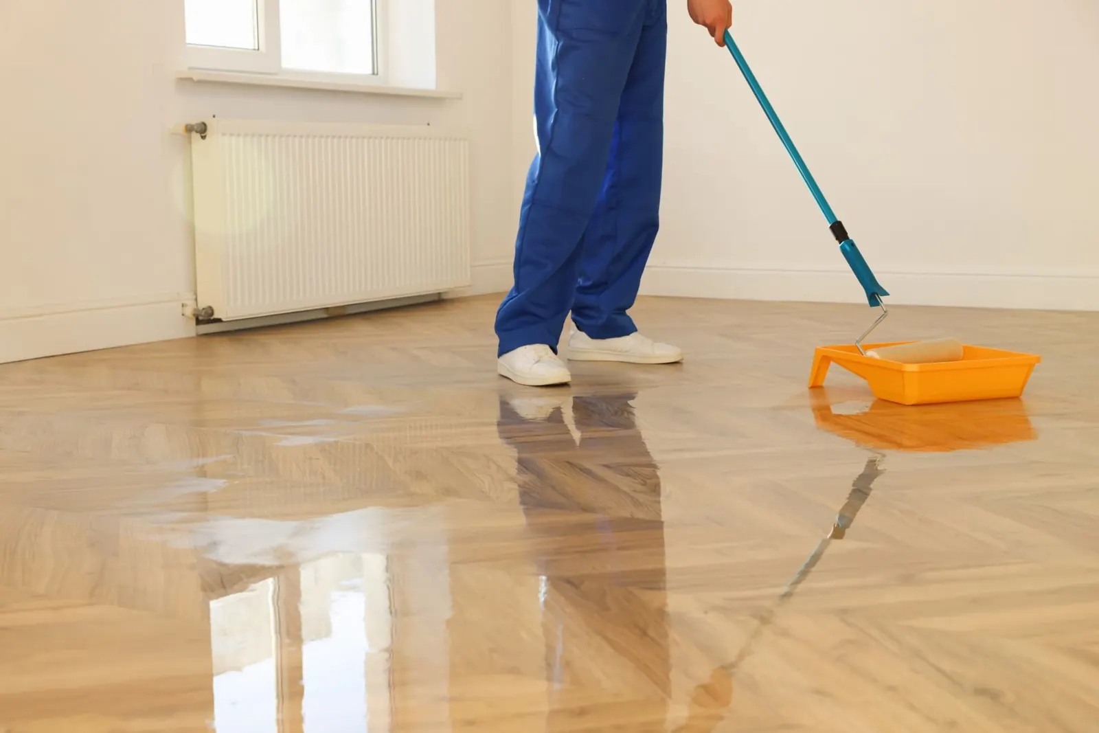 Finish coat being applied to a herringbone hardwood floor