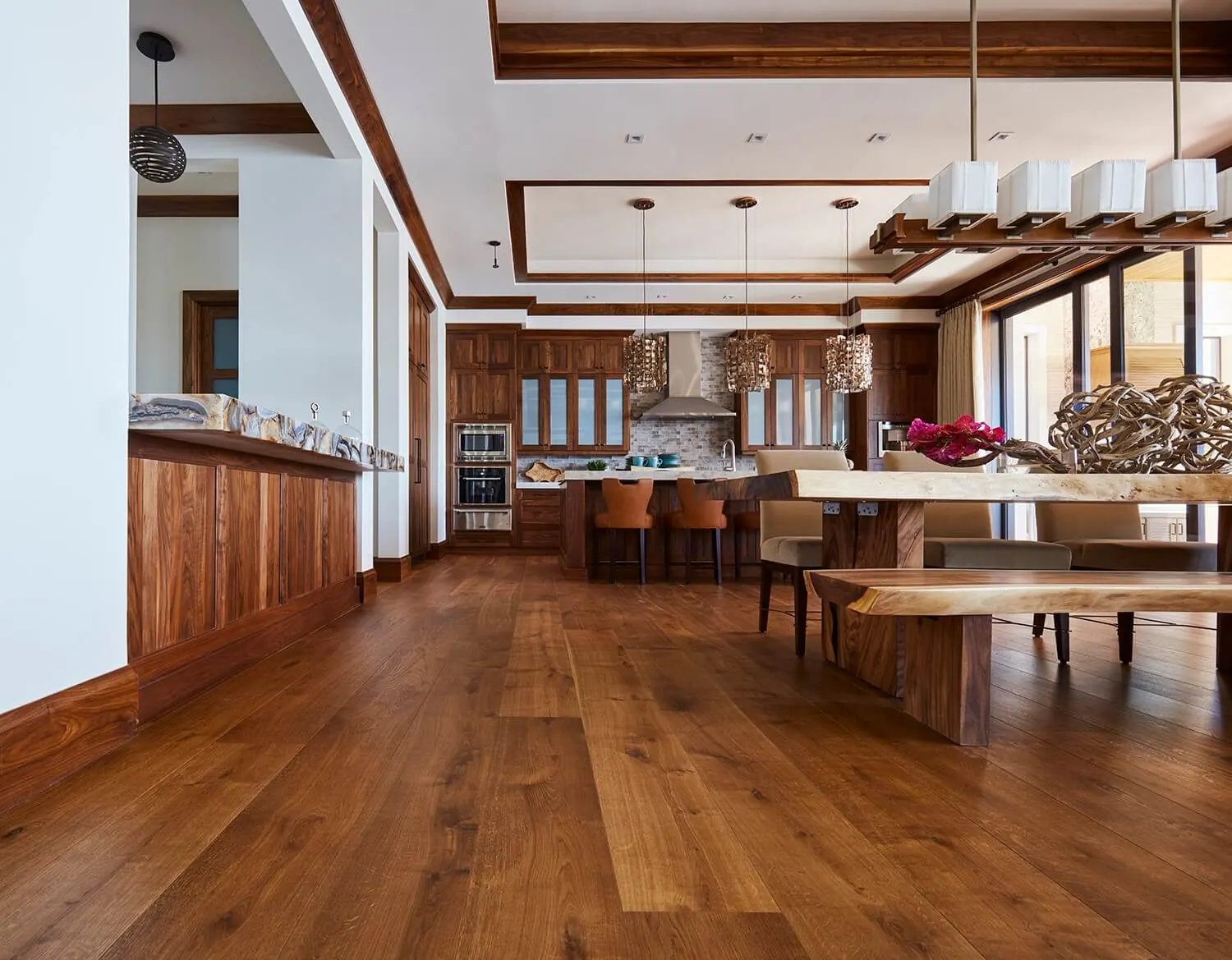Rich oak floors in an open kitchen with a long dining table