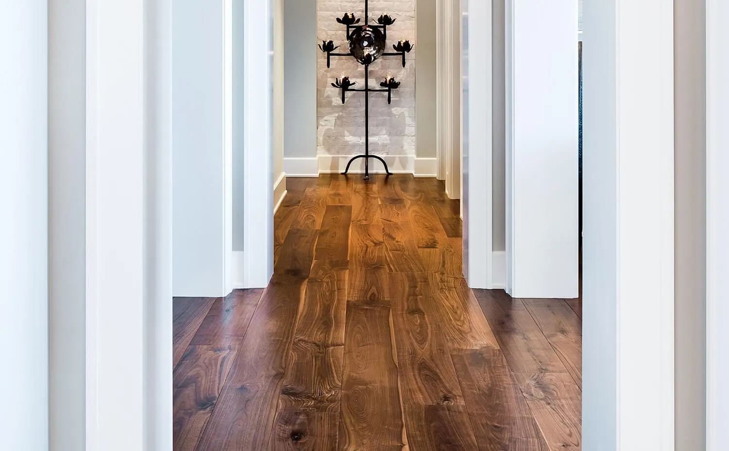 Wide plank walnut floor running down a hallway